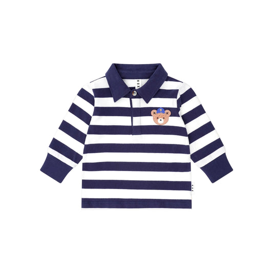 Navy and white striped polo shirt with a teddy bear emblem on a beige background