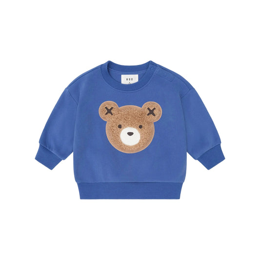 Blue children's sweatshirt with a bear face design on a beige background