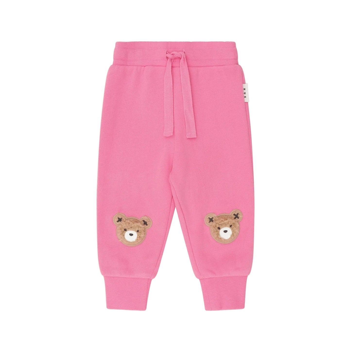 Pink children's sweatpants with bear patches on a white background