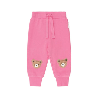 Pink children's sweatpants with bear patches on a white background