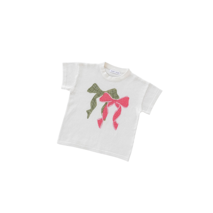 White t-shirt with green and pink bow design on a white background