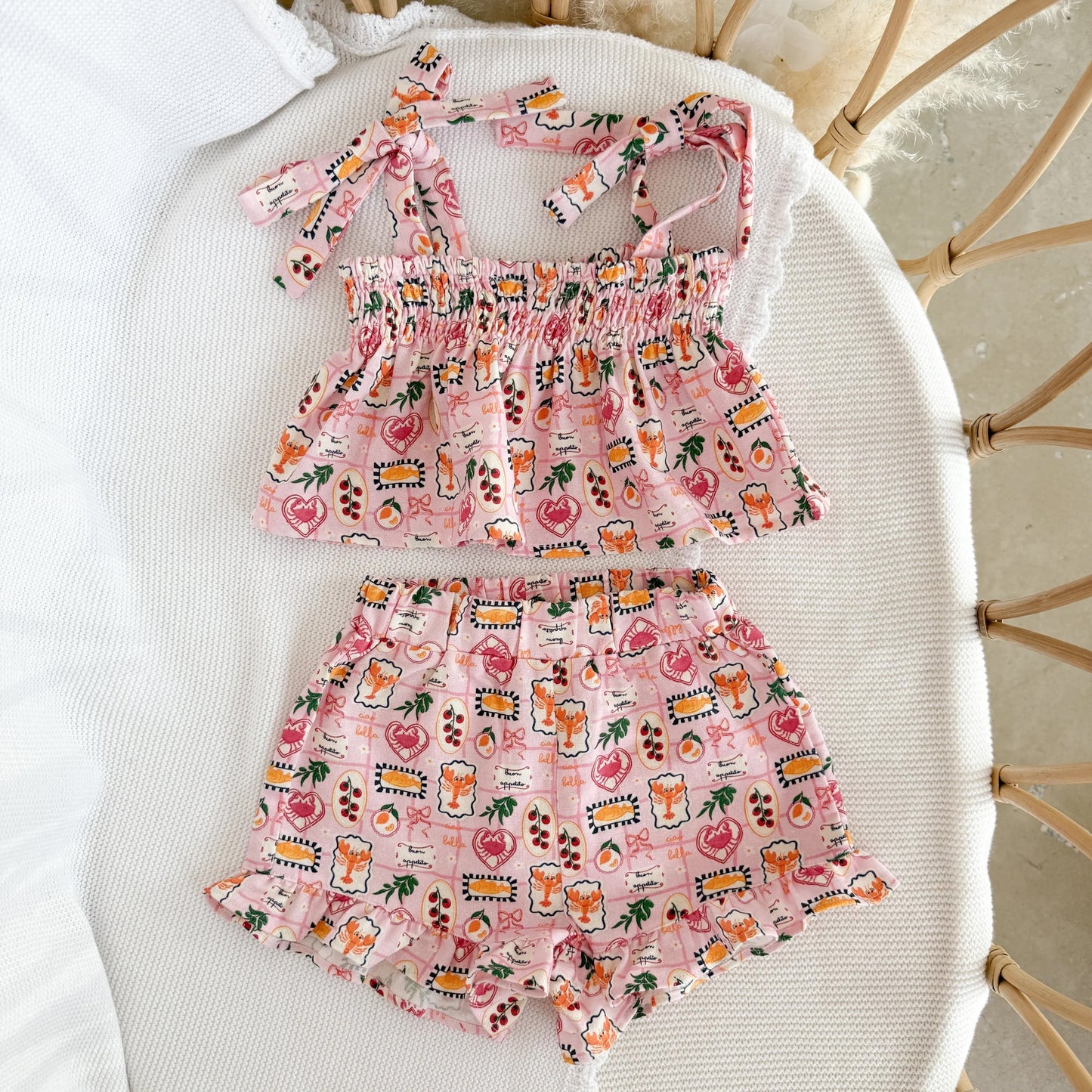 Pink children's outfit with a pattern on a white surface