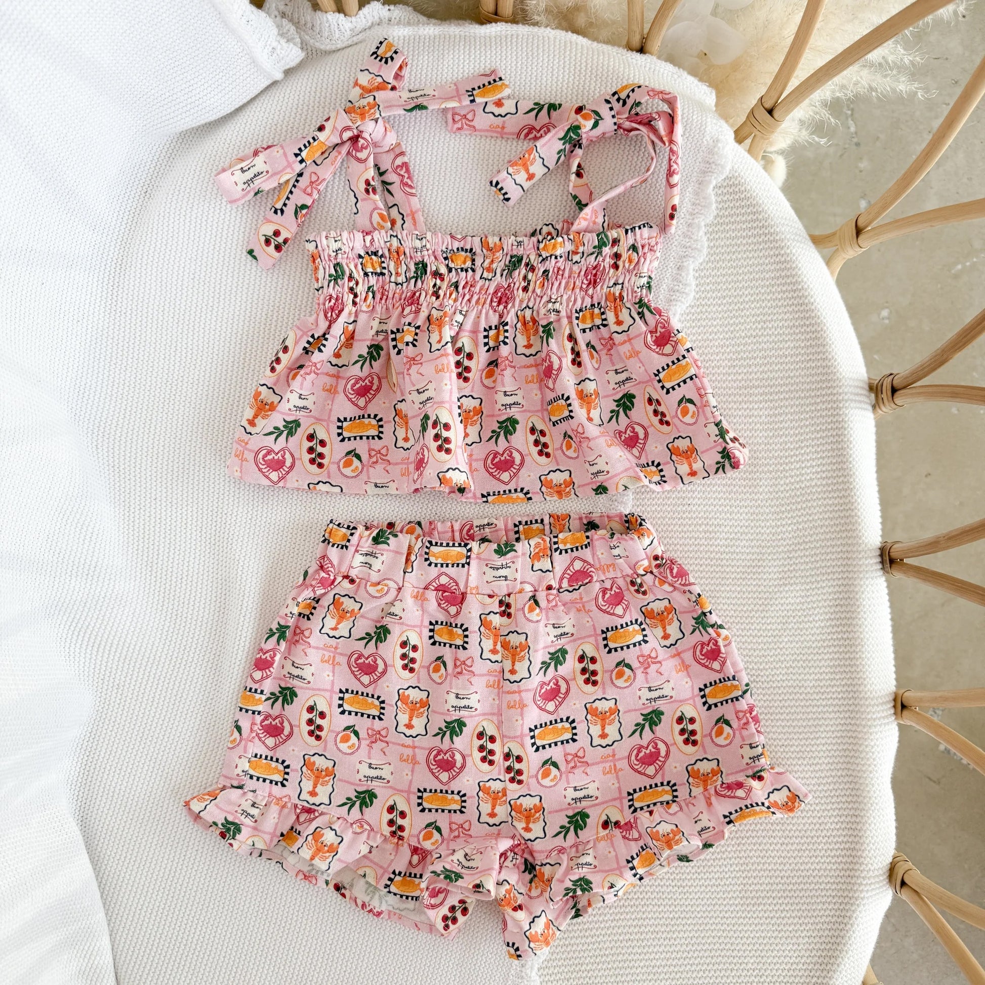 Pink children's outfit with a pattern on a white surface
