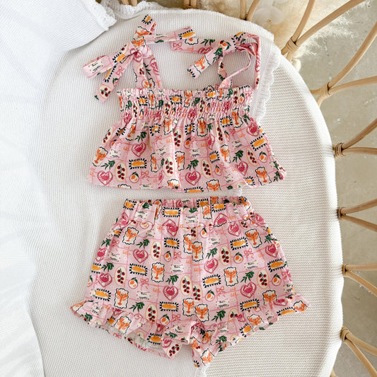 Pink children's outfit with a pattern on a white surface