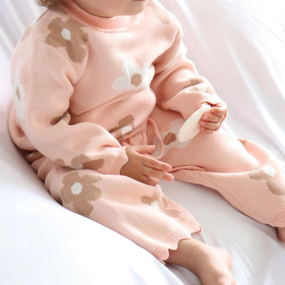 Child wearing a pink outfit with bear designs on a white background