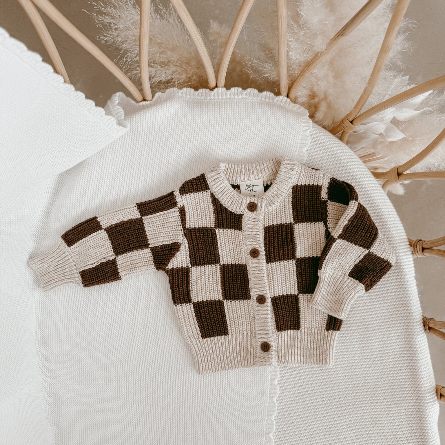 Checkered sweater on a white surface with decorative elements