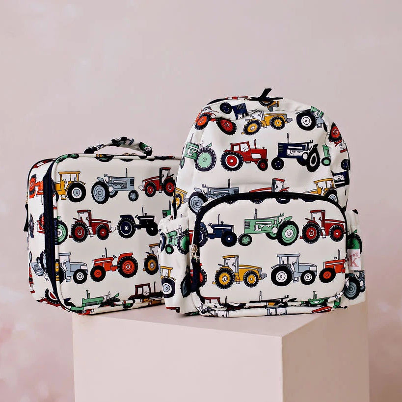 Backpack and toiletry bag with tractor pattern on a pink background