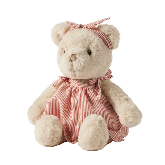 Teddy bear wearing a pink dress and headband on a white background