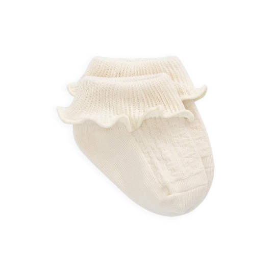 White baby bootie with ruffled top on a white background