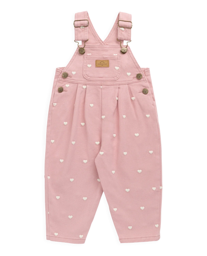 Pink children's dungarees with heart patterns on a white background