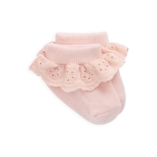Pink baby socks with ruffled top on a white background