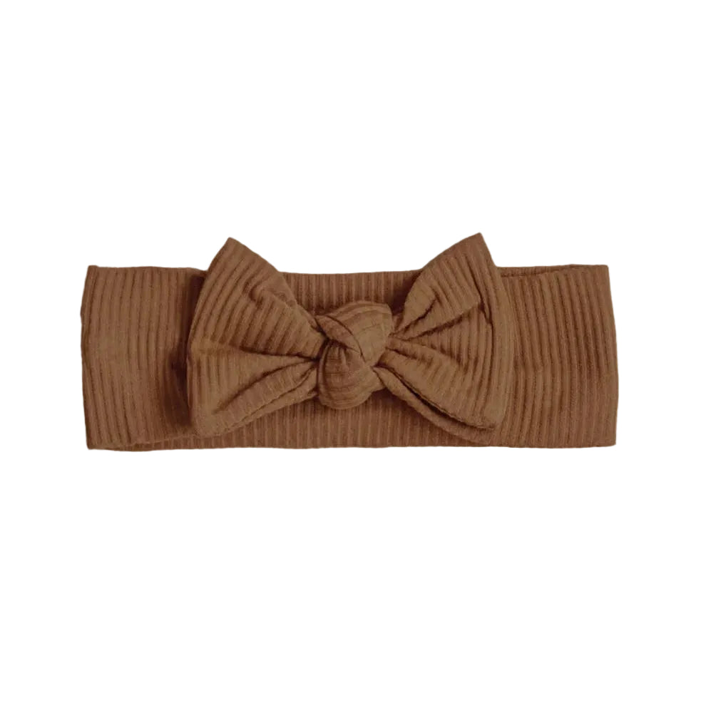 Brown ribbed headband with a large bow on a beige background