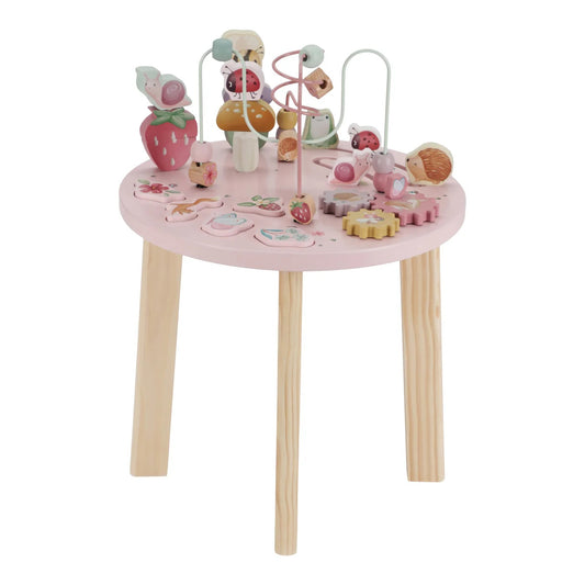 Pink children's play table with wooden legs and various toys on a white background