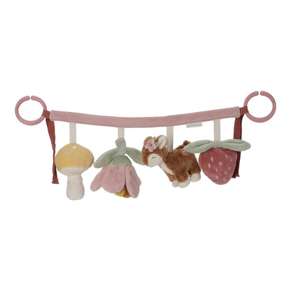 Baby crib mobile with plush toys including a mushroom, flower, and animal on a pink bar.