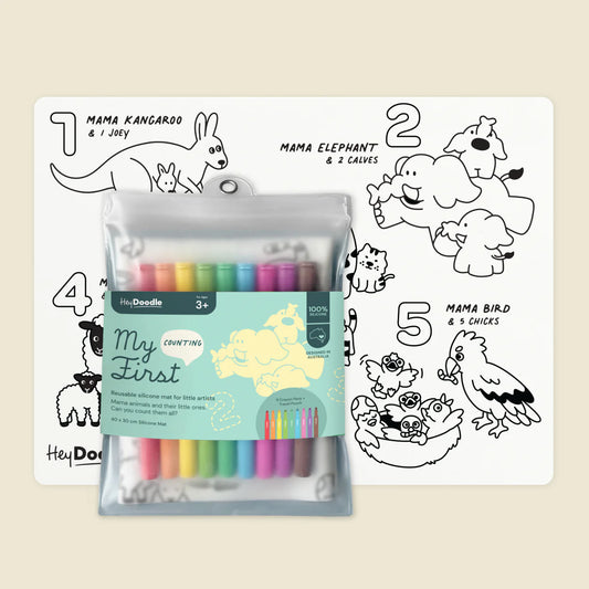Set of colorful markers with a coloring book featuring animal illustrations on a beige background