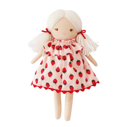 Doll wearing a dress with strawberry pattern on a white background