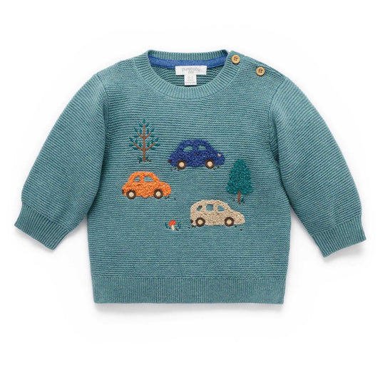 Teal sweater with embroidered cars and trees on a white background