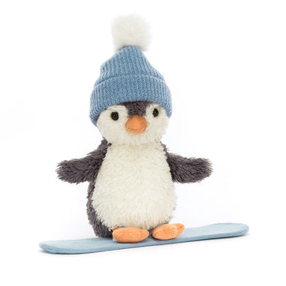 Stuffed penguin toy wearing a blue knitted hat on a white background