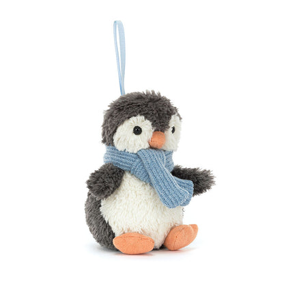 Stuffed penguin toy with a blue scarf on a white background