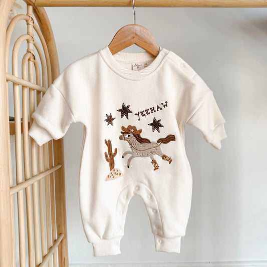 Baby romper with cowboy design and 'Yeehaw' text on a hanger.