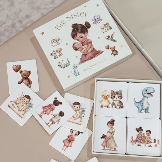 Board game for 'Big Sister' with illustrated cards and a book on a beige surface.