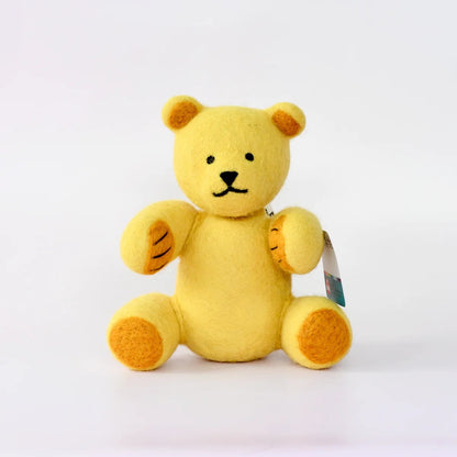 A small yellow plush teddy bear with embroidered black facial features and orange-brown paw pads, sitting against a plain white background with a small hangtag attached.