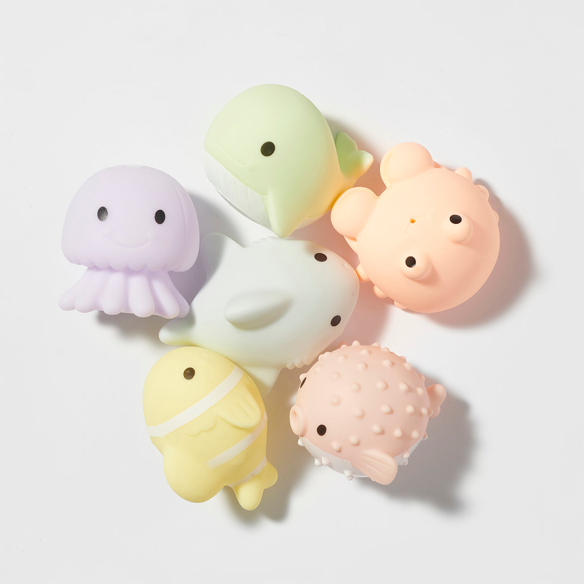 Set of pastel-colored silicone animal-shaped coasters on a white background