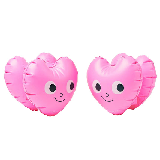 Two pink heart-shaped balloons with faces on a white background