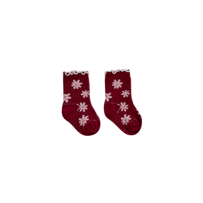 Pair of red socks with white flower patterns on a white background