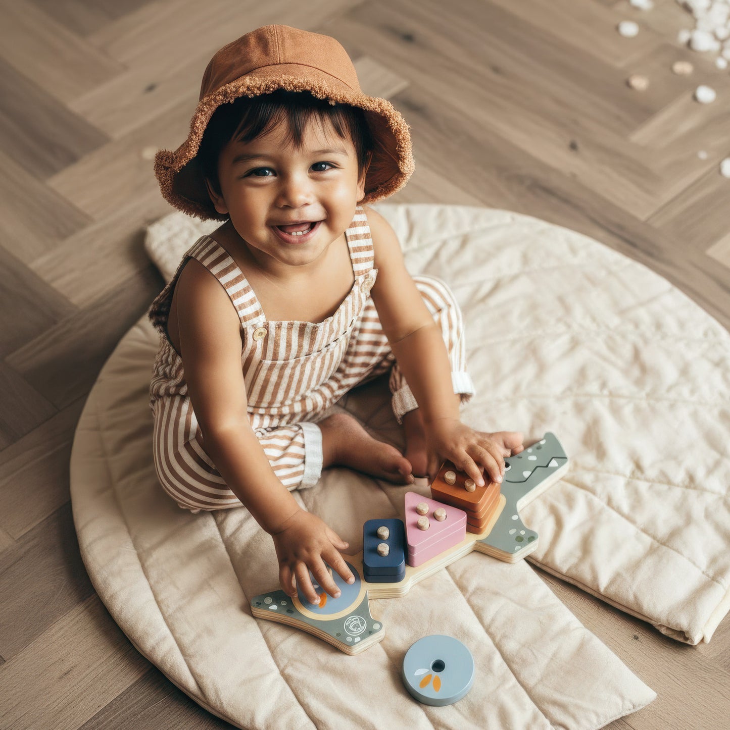 Child playing with wooden toys on a round mat in a room with wooden flooring.