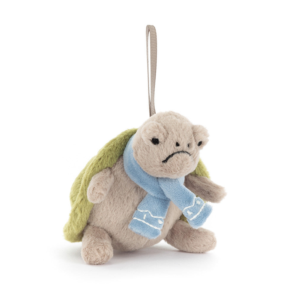 Stuffed turtle toy with a blue scarf on a white background