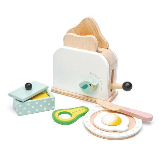 Wooden toy toaster set with avocado, egg, and toast on a white background