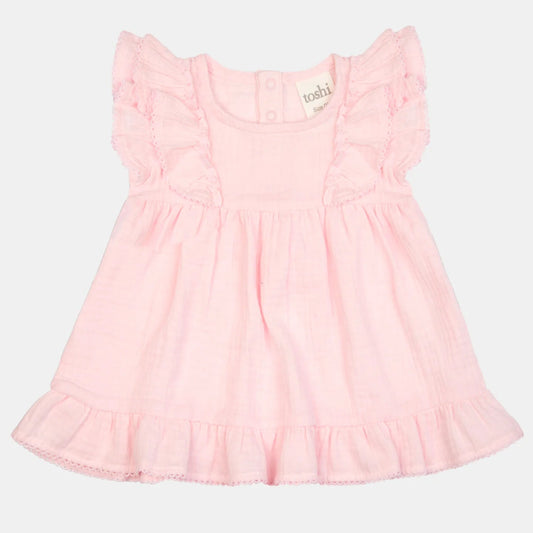 Pink dress with ruffled sleeves on a light gray background