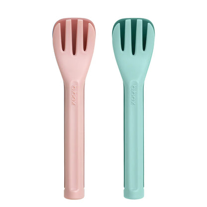 Two colorful kitchen utensils, one pink and one green, on a white background.