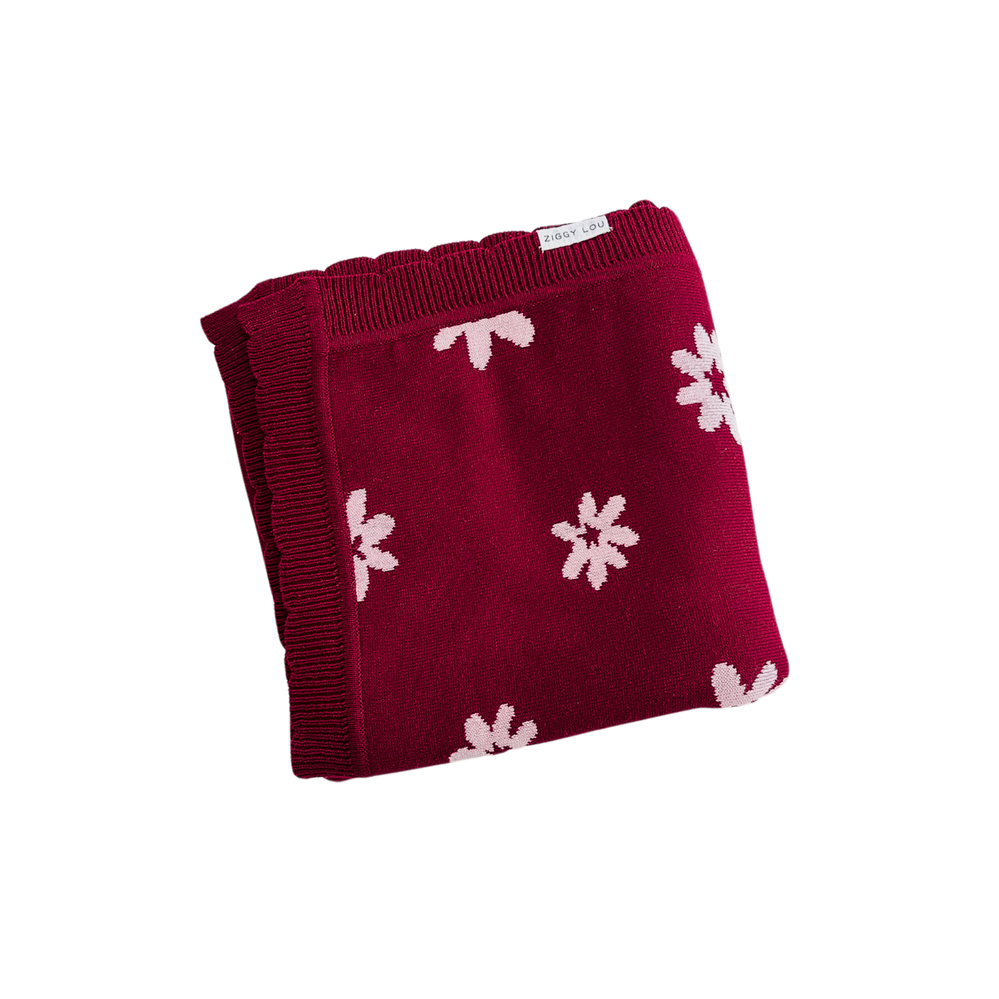 Red blanket with white floral patterns on a white background