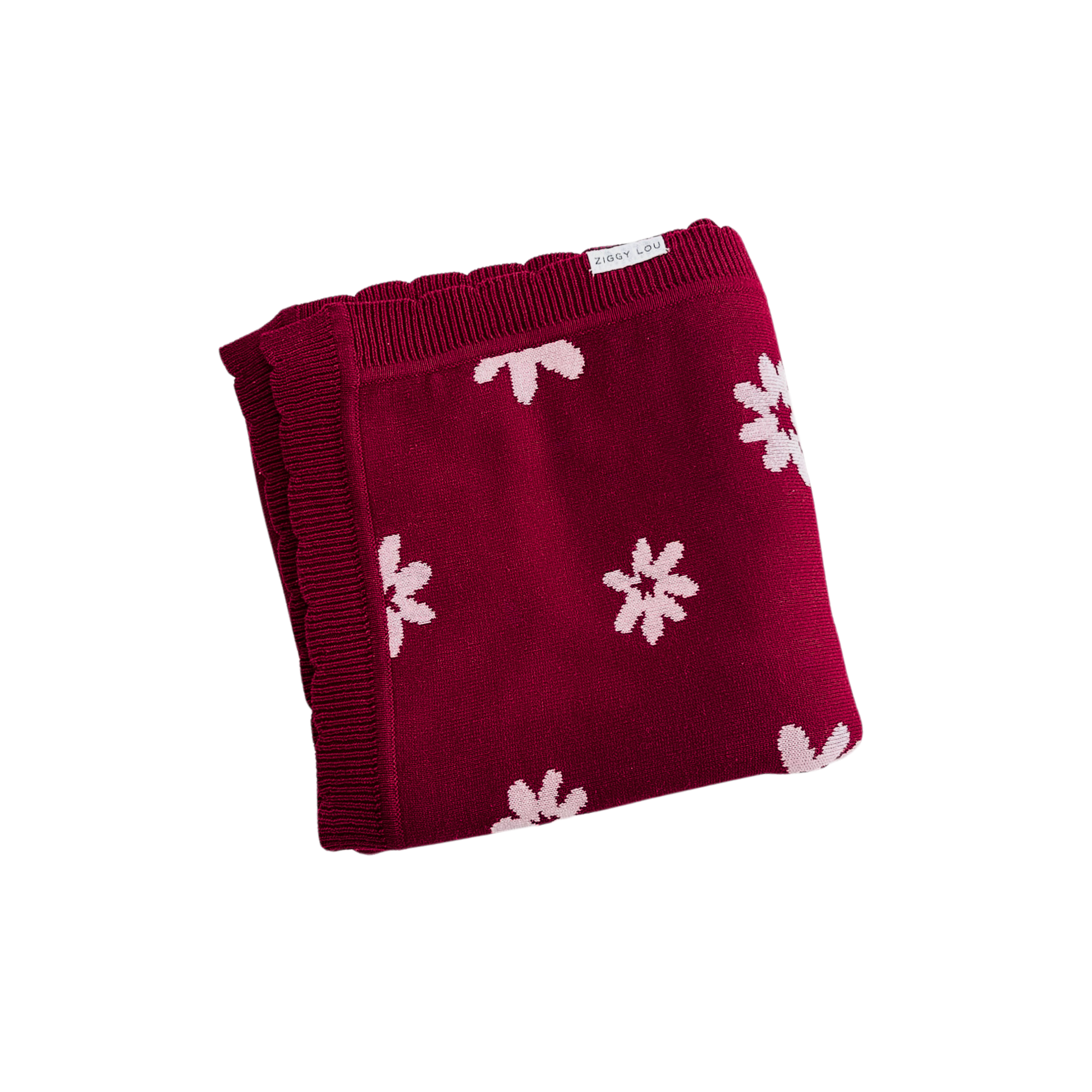 Red blanket with white floral patterns on a white background