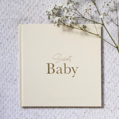 Card with 'Sweet Baby' text on a textured surface with dried flowers.