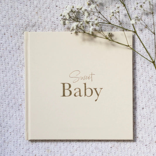 Card with 'Sweet Baby' text on a textured surface with dried flowers.