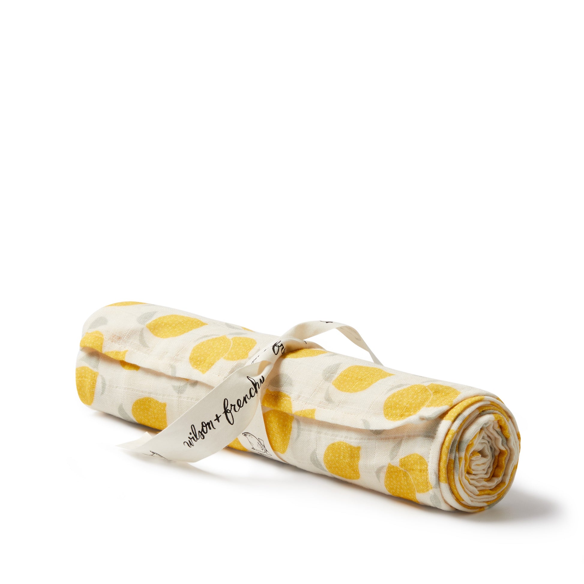 Rolled-up fabric with yellow polka dots and a visible brand label on a white background