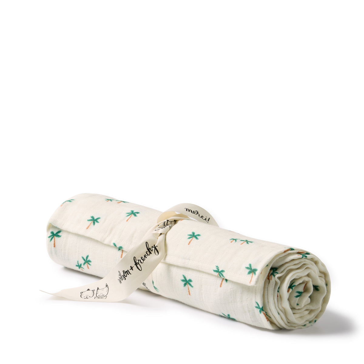 An off-white muslin baby blanket rolled up and tied with a cream ribbon printed with green palm trees, on a white background.