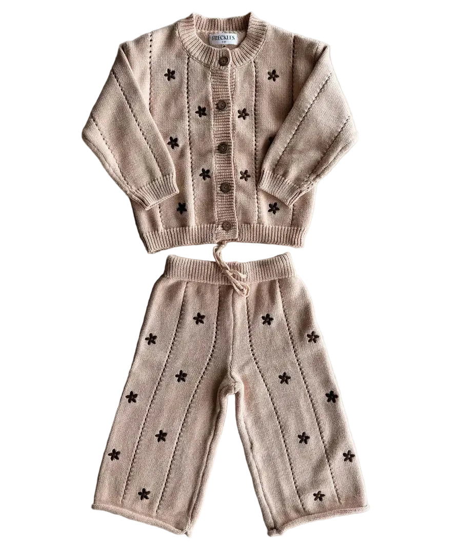 Children's beige sweater and pants set with star patterns on a gray background