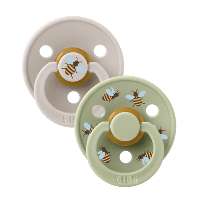 Two baby pacifiers with bee designs on a white background
