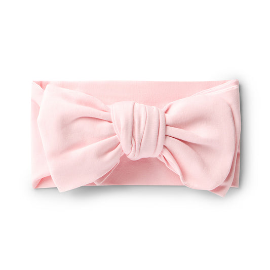 Pink headband with a large bow on a white background
