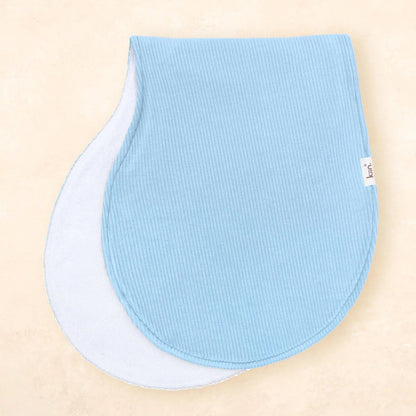 Two blue baby bibs on a beige background
