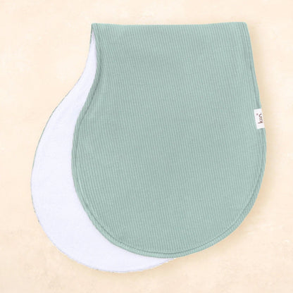 Two green baby bibs on a beige background