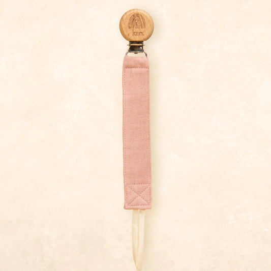 Pink textured pen with a round wooden top on a beige background