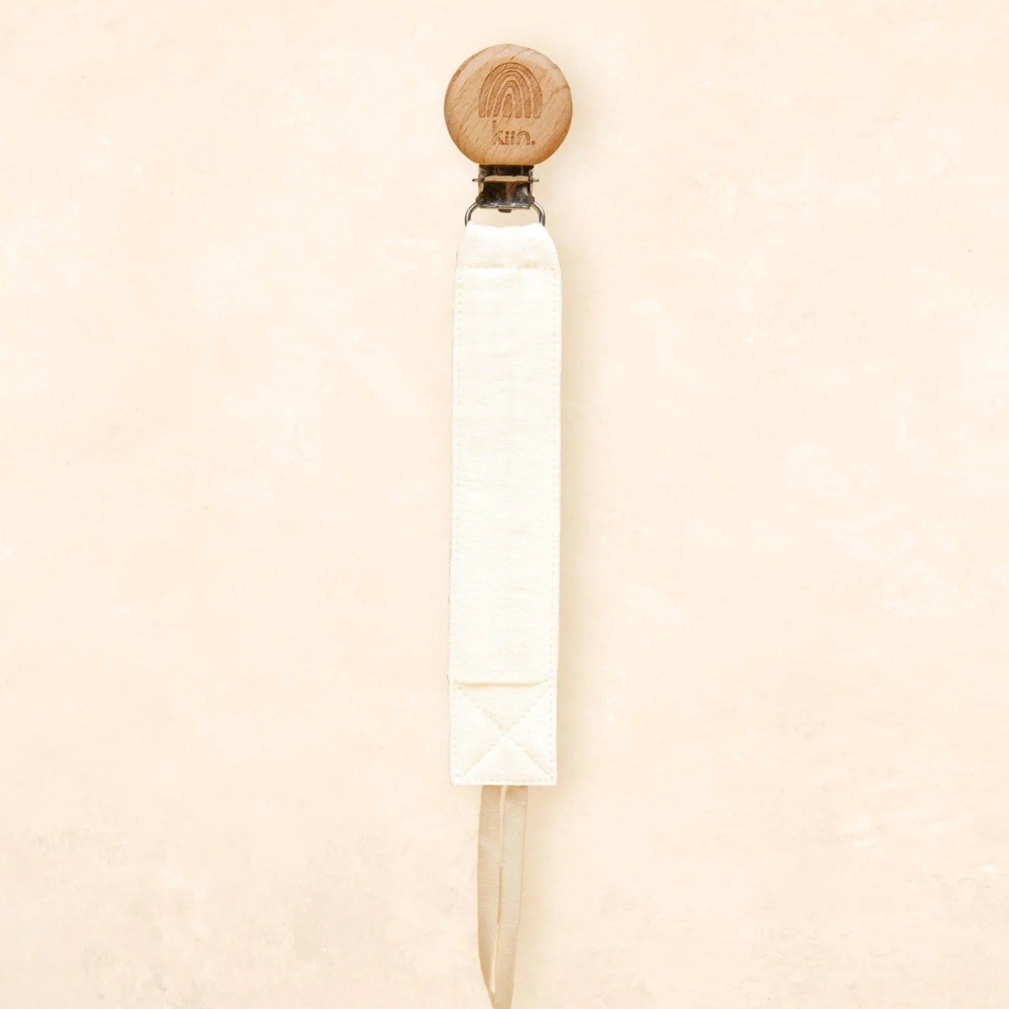 White cylindrical object with a wooden top on a beige background