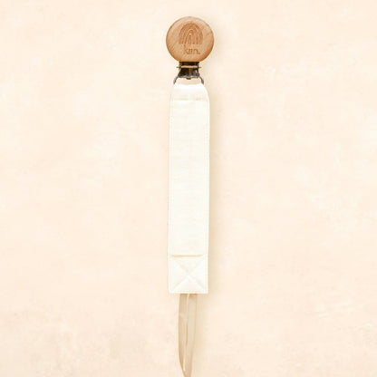 White cylindrical object with a wooden top on a beige background