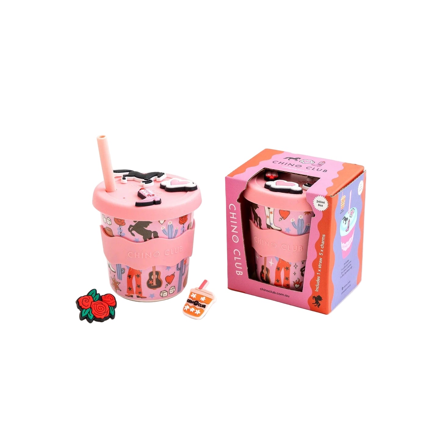 Pink tumbler with straw and decorative elements next to its packaging on a white background