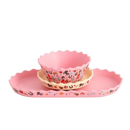 Set of pink children's bowls and plates with cartoon designs on a white background